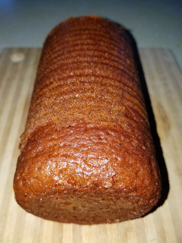 Sliced brown bread loaf on a wooden board
