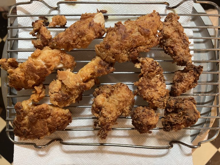 Crispy fried chicken strips resting on a baking rack